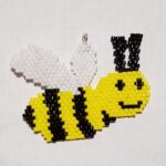 charm of a yellow and black bee with white wings and black eyes and smile