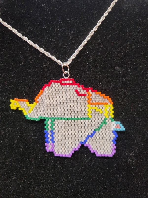 beaded elephant with the lines that mimic origami. The lines are in the pride flag colors. The tail is in the colors of the trans flag. The rest of the elephant is grey